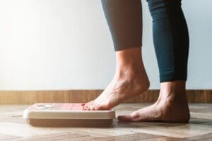 Vrouw stapt met blote voeten op weegschaal